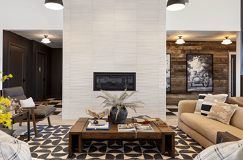 A living room with a couch and a coffee table and a fireplace